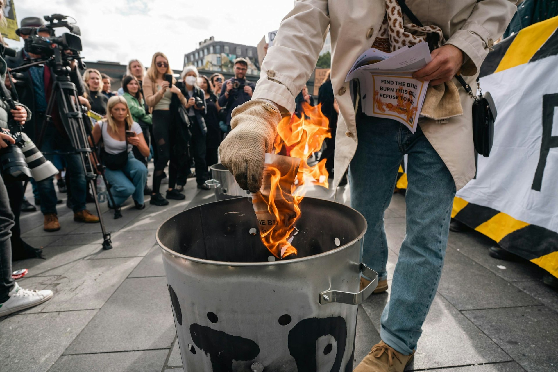 Photos of protestors burning their energy bills in London