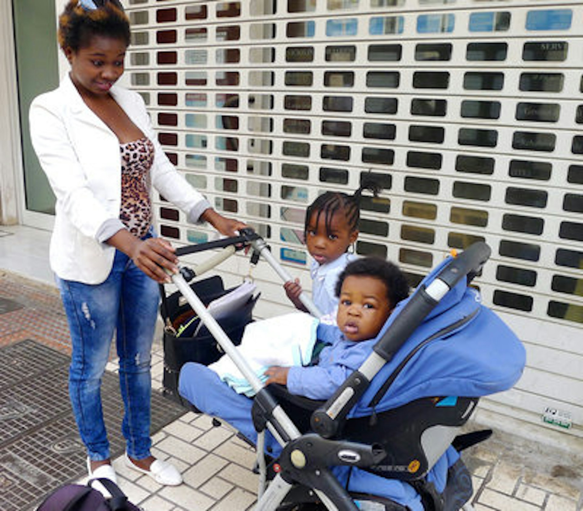 Tatiana Kanga, 25, takes her children Chantel, 3, and Antoni, 7 months, on a walk through the city of Malaga, in southern Spain. Lauren Frayer/NPR