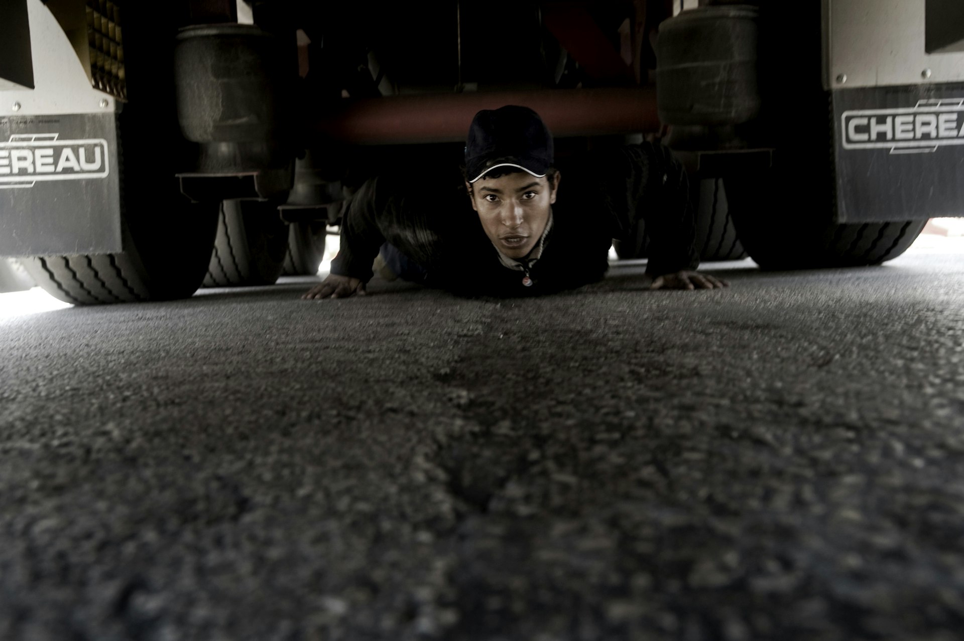 A young Afghan tries to get himself in the axle of a truck that is headed for Italy through the Greek harbour of Patras. Hiding in the axle of a truck is about as dangerous as it gets. Get it wrong, and it can end up costing you your legs.