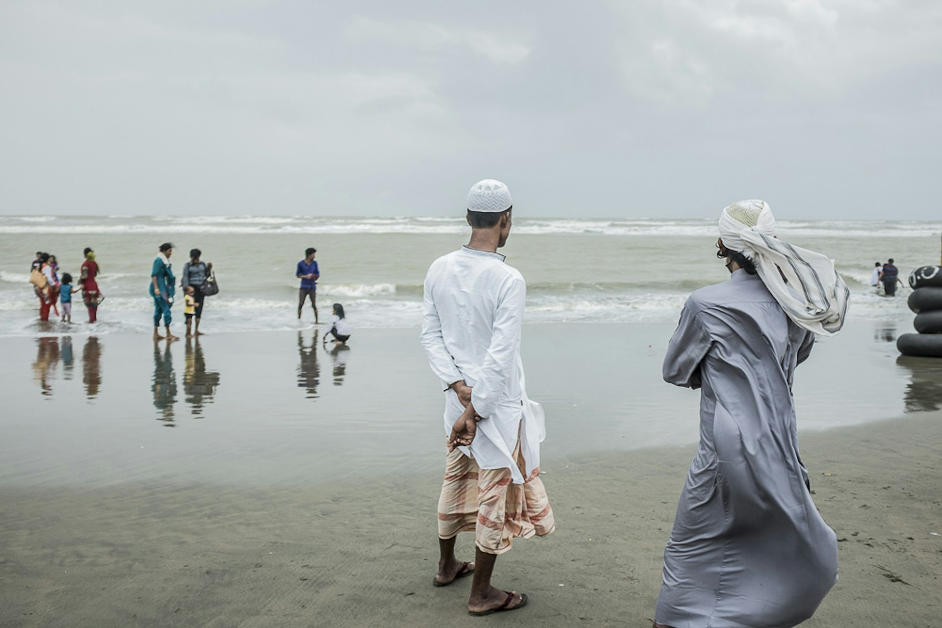 Two young men, watching the sea on Cox's Bazar's beach, Banglade