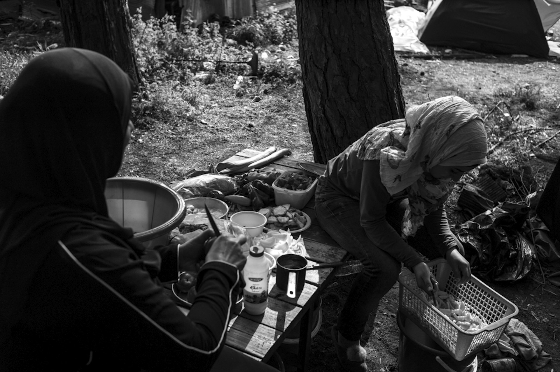Amira (left) and Shayma (right) peeling potatoes in their campsite above the road leading to the Macedonian border. They have been living in the camp for two months after fleeing Raqqa in Syria.