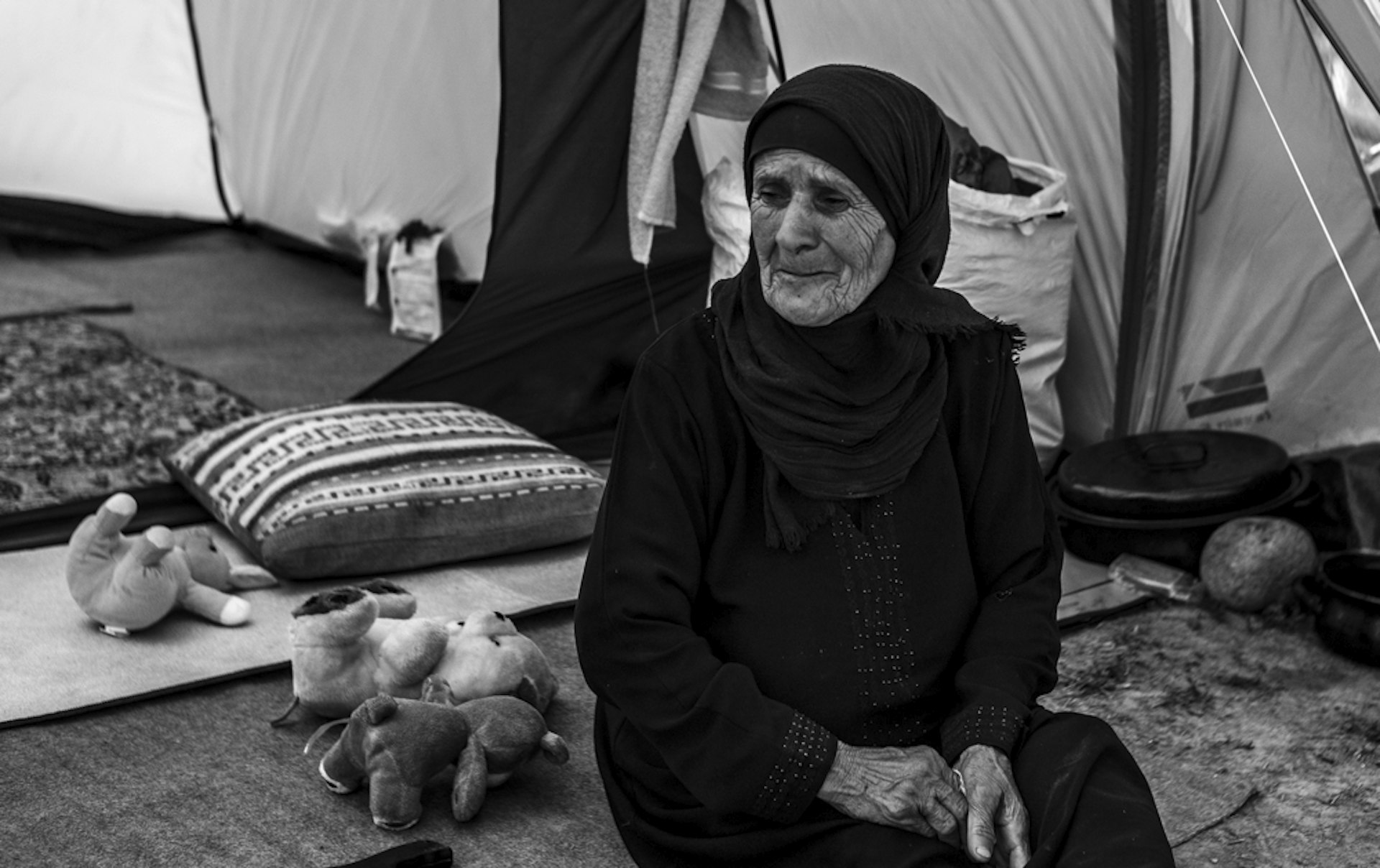 Aseel from Homs, Syria sits in the entrance to her tent in Idomeni.