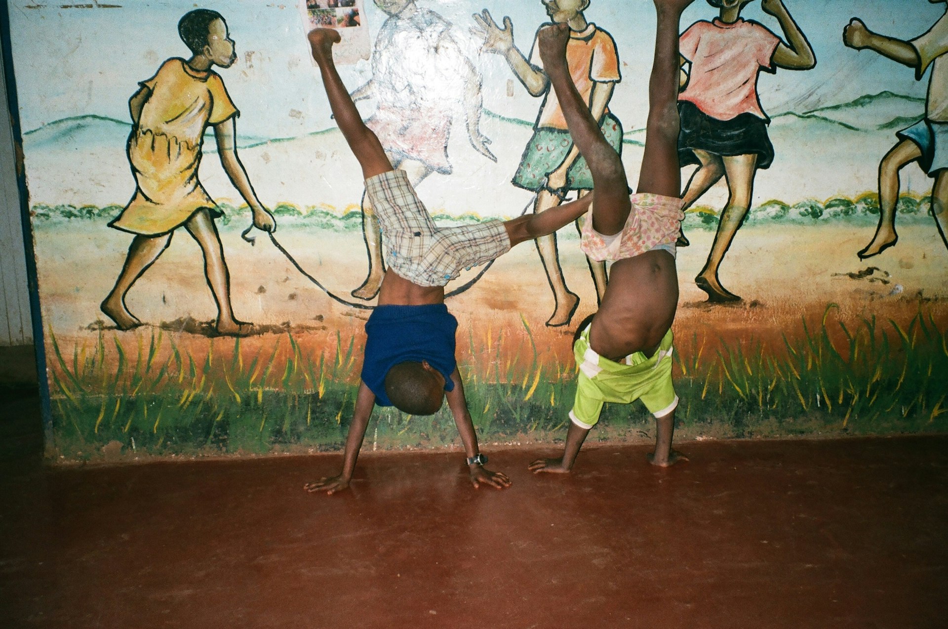 Gilbert and Bahati are practicing their acrobatics. Kelvin, 14