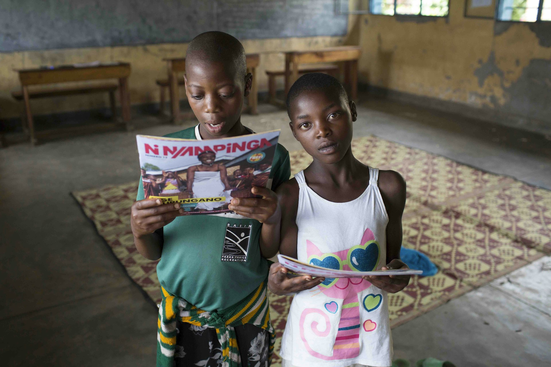 Two girls in the 12+ classroom with copies of Ni Nyampinga