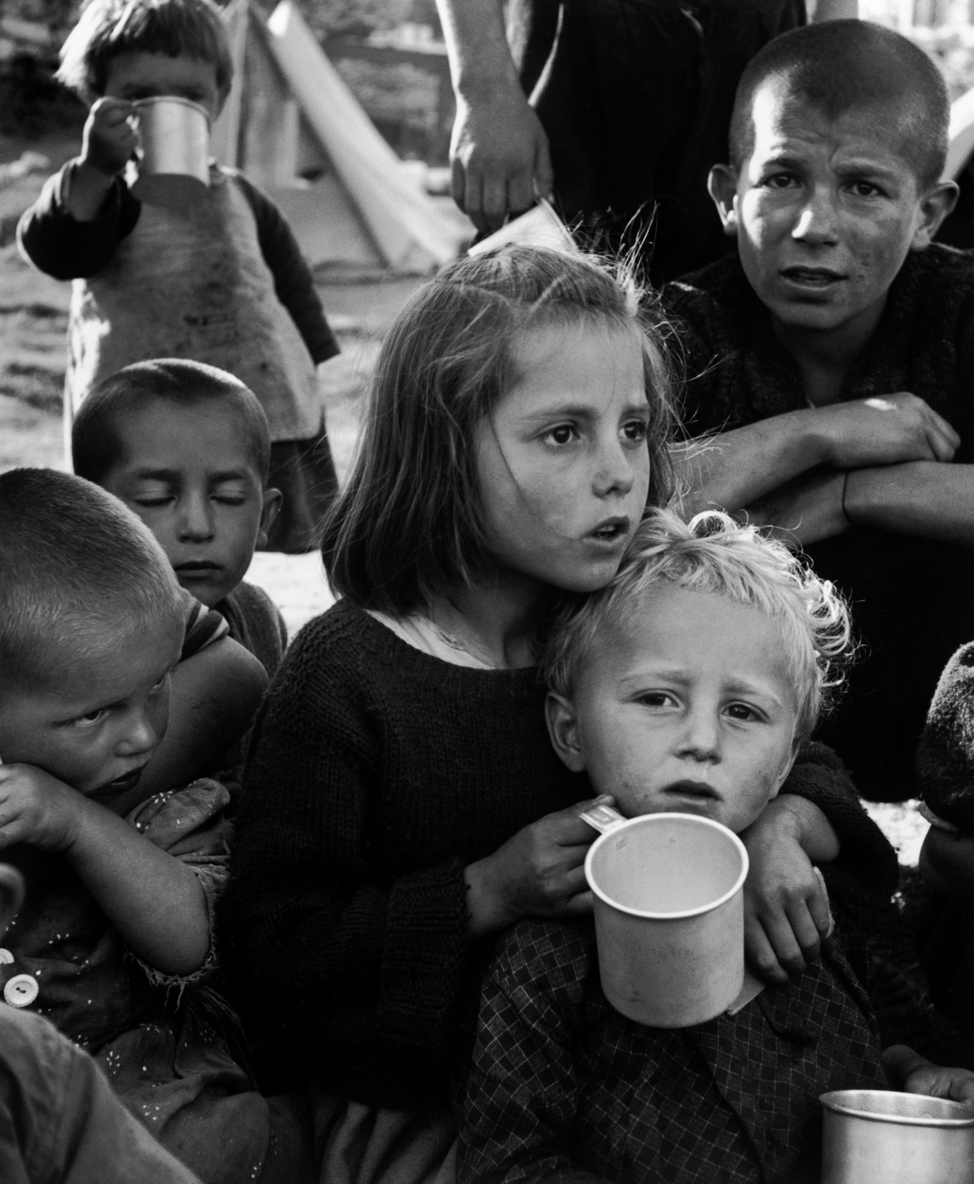 Refugees from the civil war areas. Waiting for this unfamiliar stuff, UNICEF milk (reconstituted from powdered milk) distributed for the first time at the refugee camp. Ioannina, Greece 1948 © David Seymour (Chim)
