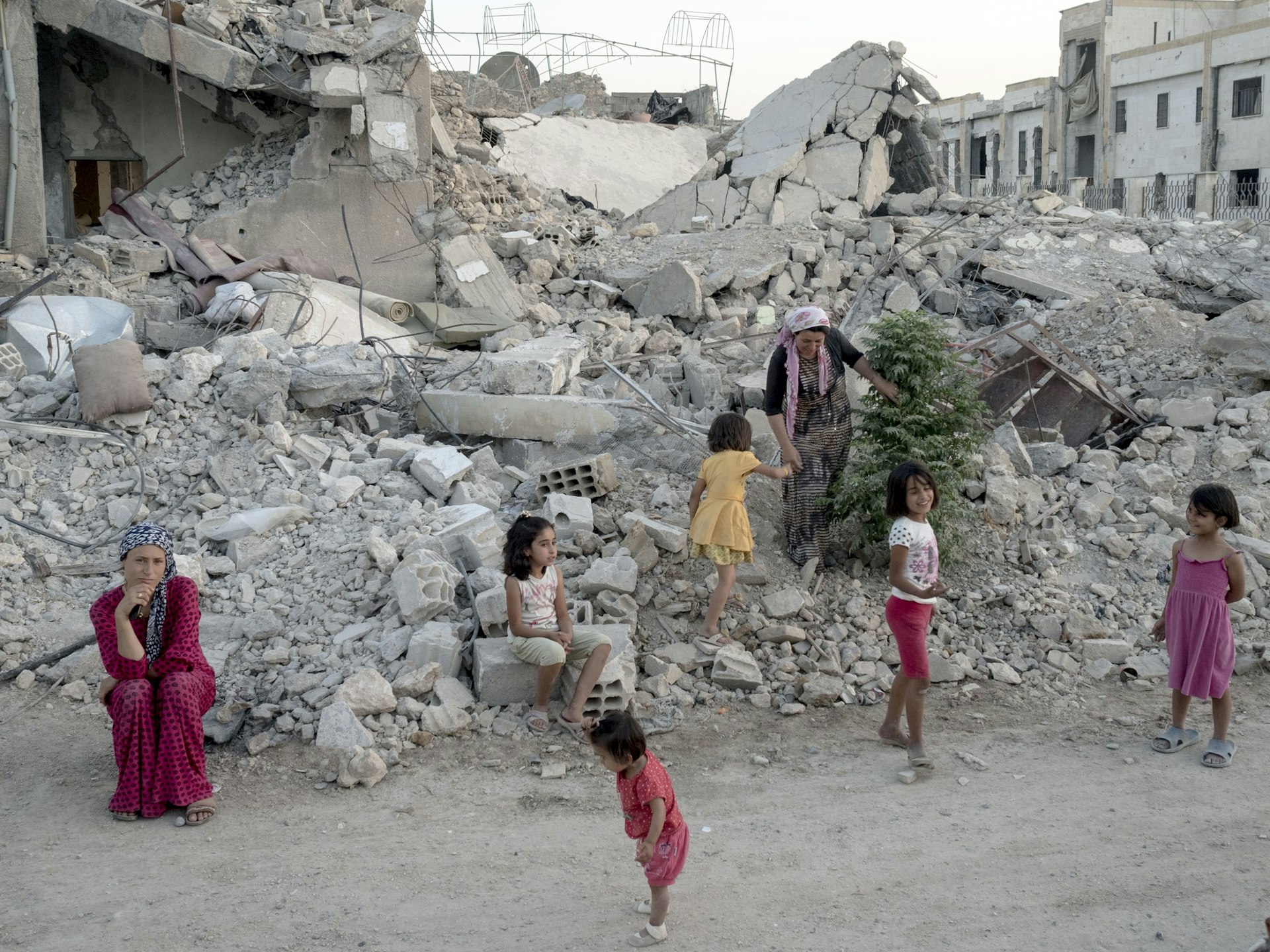 A family stands on what is left of their home. SYRIA. Kobani / Kobane (Arabic: Ayn al Arab). 06 August 2015. © Lorenzo Meloni