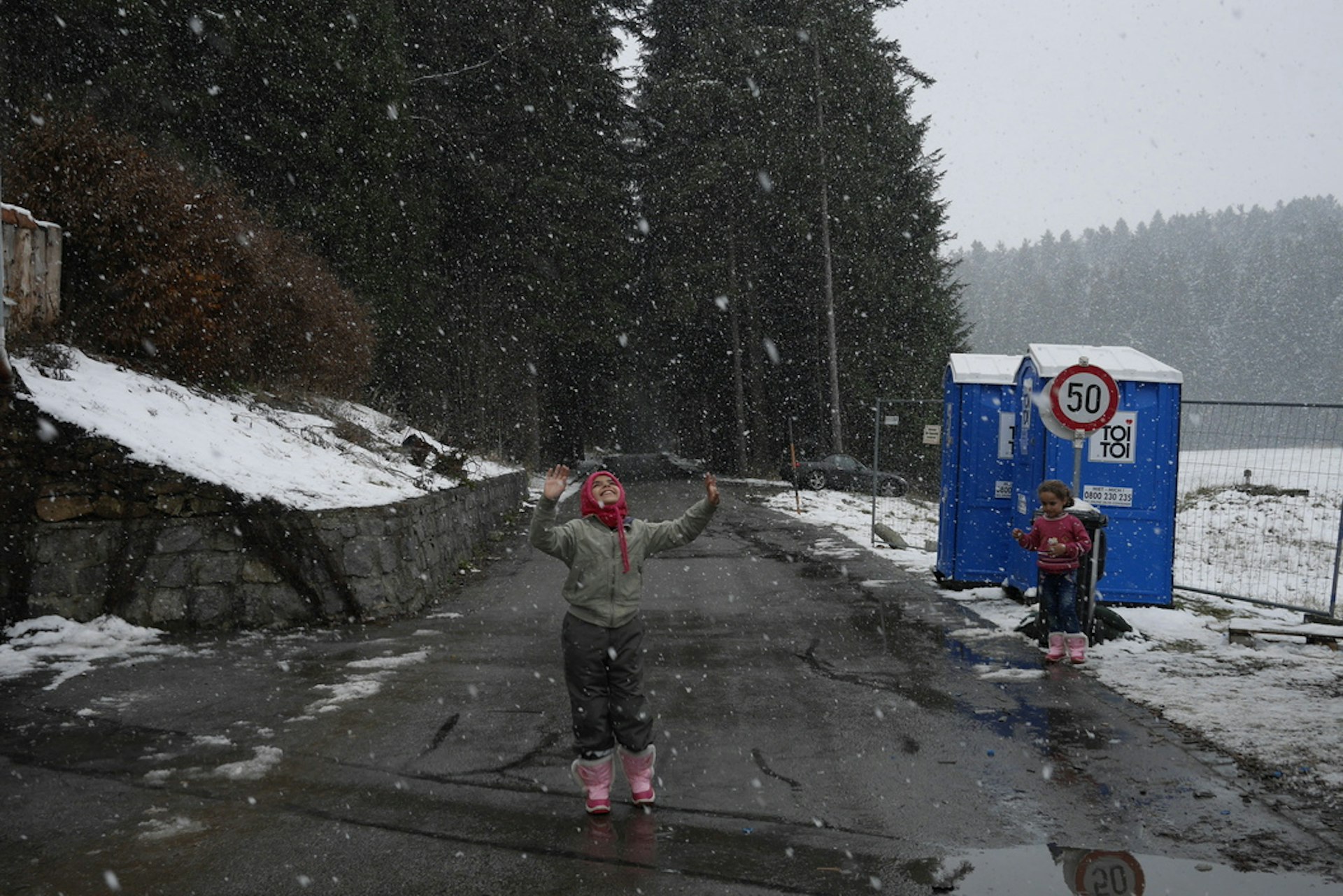 Thomas Dworzak GERMANY. AUSTRIA. Wegscheid border post. November 2015. Syrian refugees at Austrian/German border, waiting to cross to Bavaria. The girl is still on the Austrian side.
