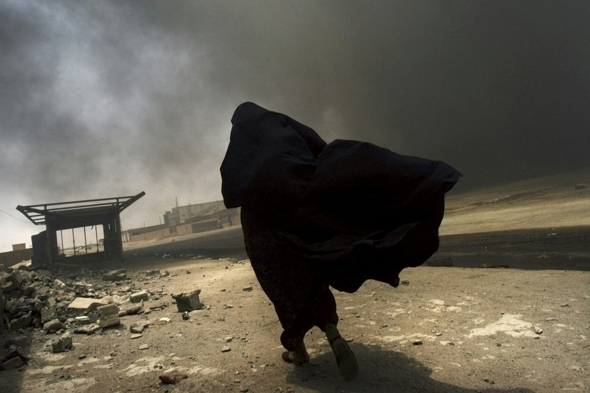 An Iraqi woman searches for her husband at the site of a liquid-gas factory fire, allegedly set by looters in Basra, May 2003. 