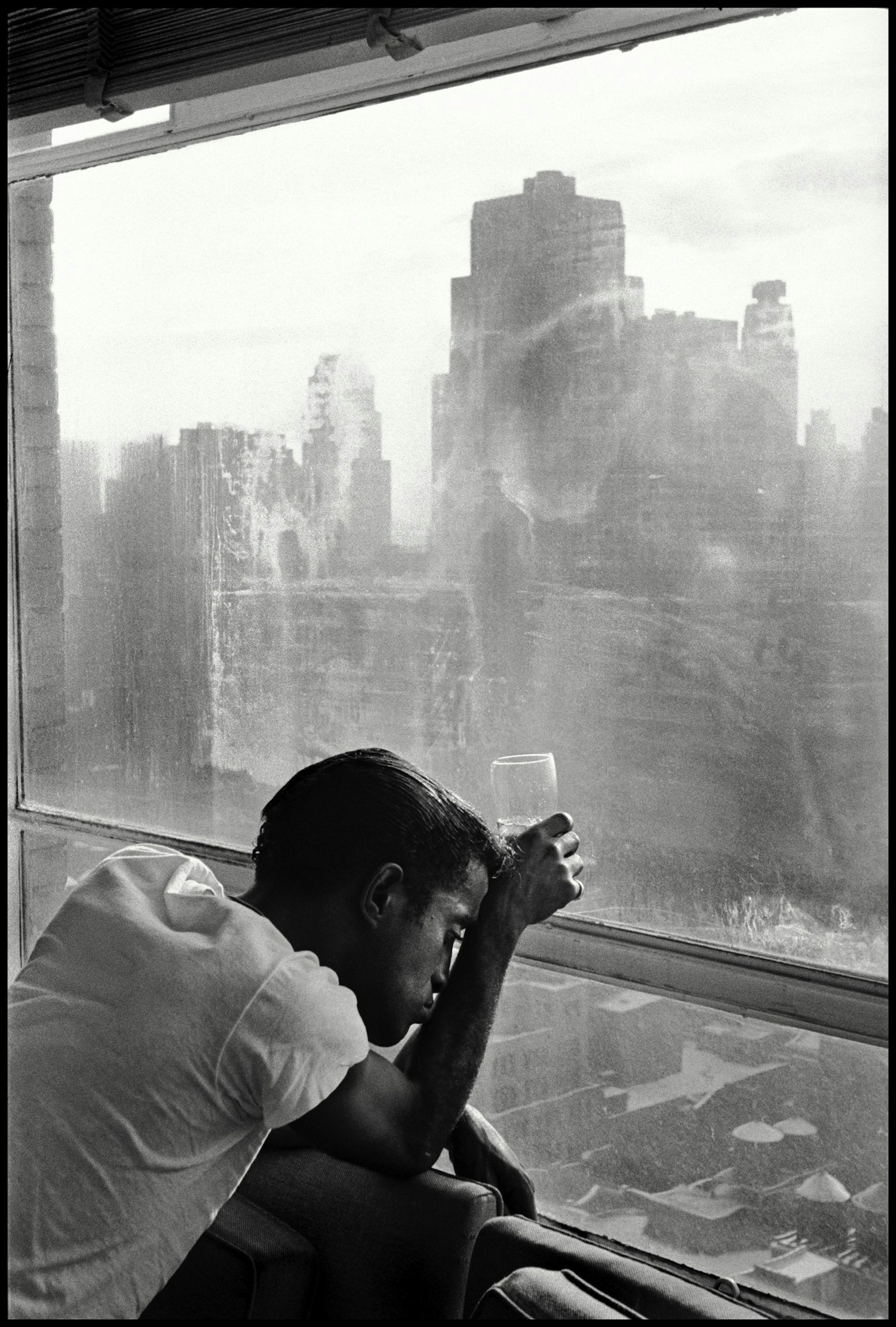 USA. New York City. 1959. Sammy DAVIS Jr. looks out a Manhattan window. Photo by Burt Glinn. 