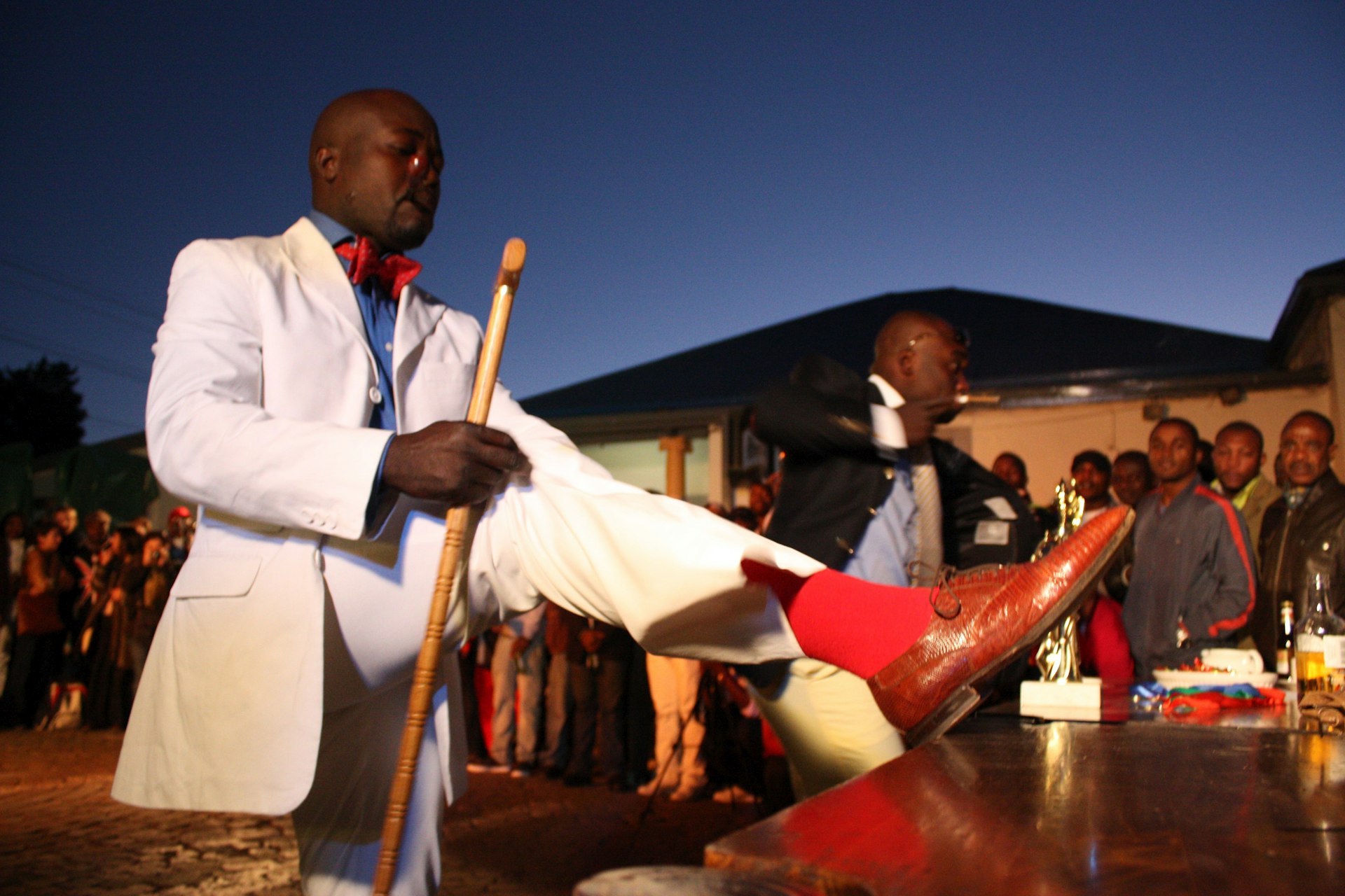 A Congolese national parades in front of fans during the La Sape competition at Kin Malebo restaurant, in Yeoville, Johannesburg South Africa, 30 May 2009. Photography Daniele Tamagni.