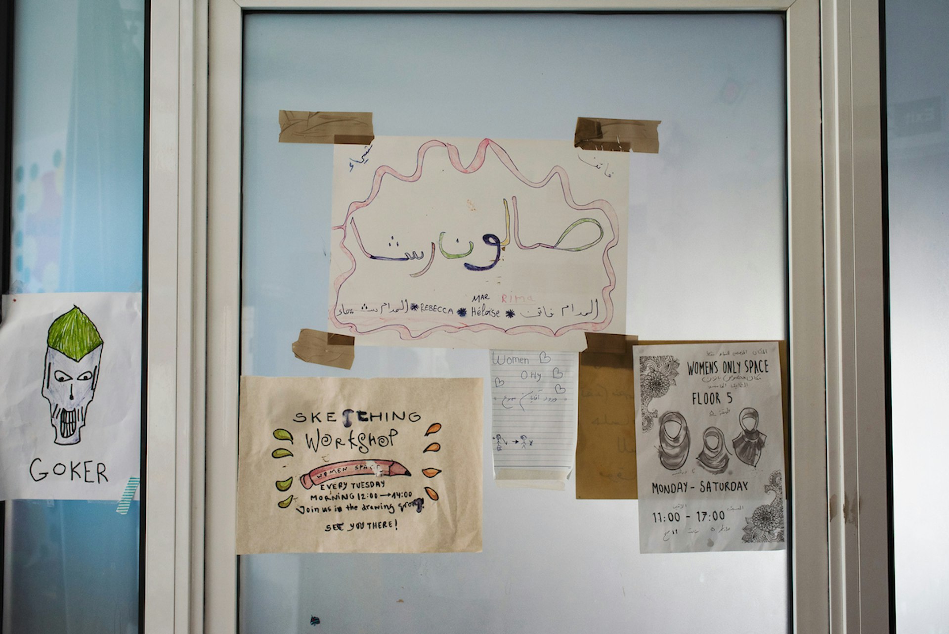 Posters on a door at Khora, refugee centre in Athens.