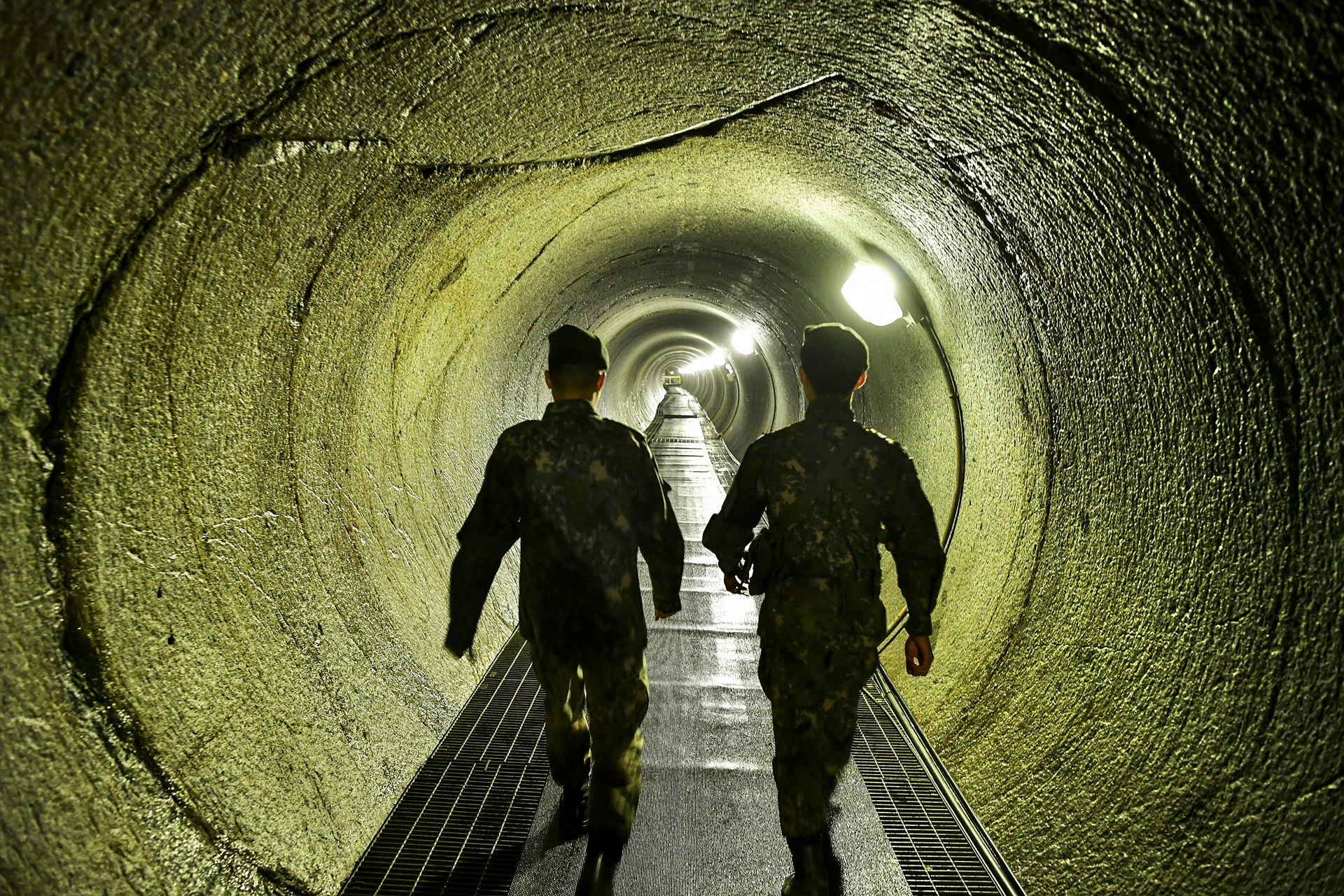 Two South Korean soldiers walk along the long counter tunnel connecting to the North Korean infiltration tunnel.