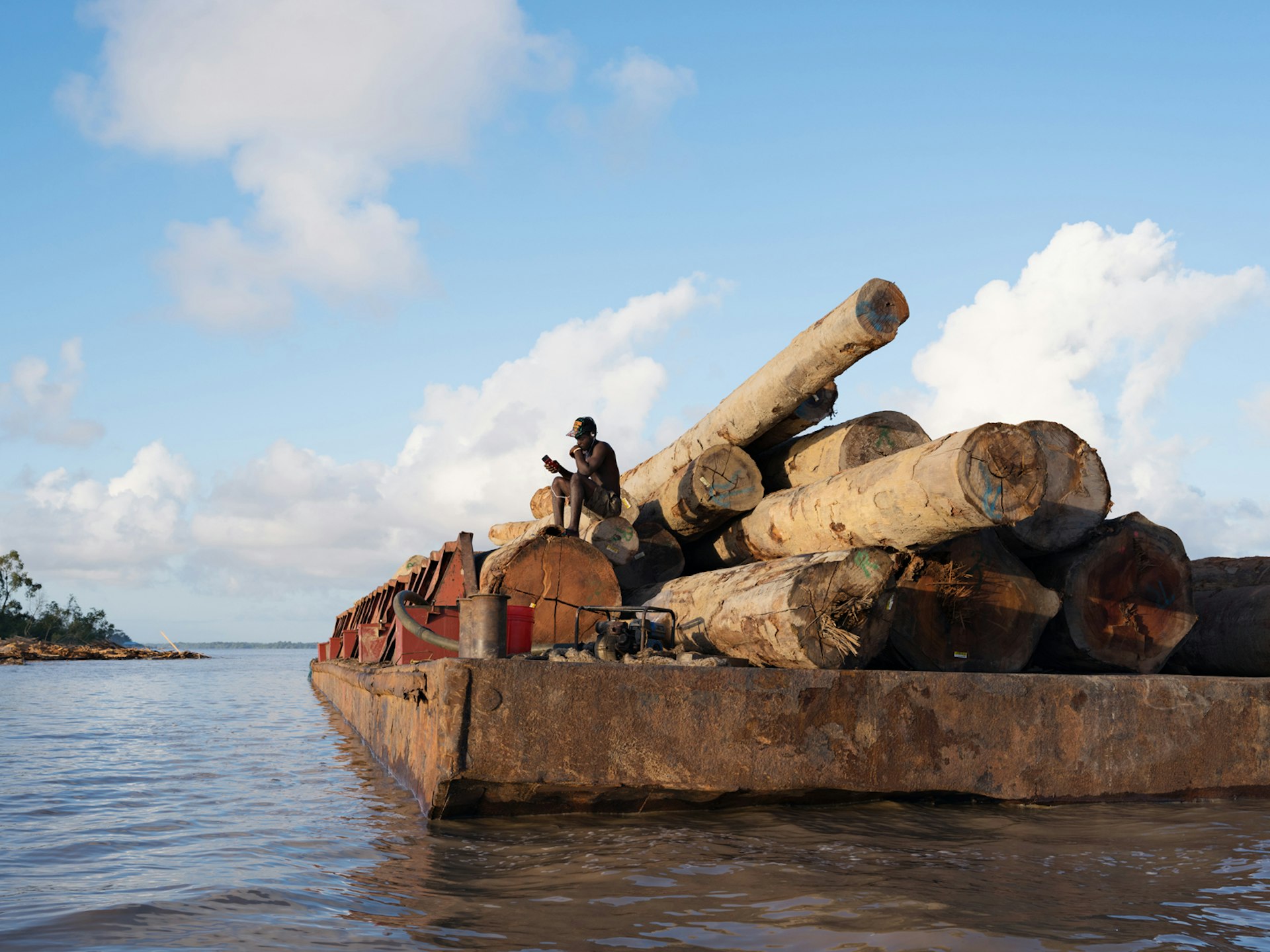 Kurt guarding logs for export to China, Essequibo River, Guyana. © Lucas Foglia, courtesy of Michael Hoppen Gallery, London.