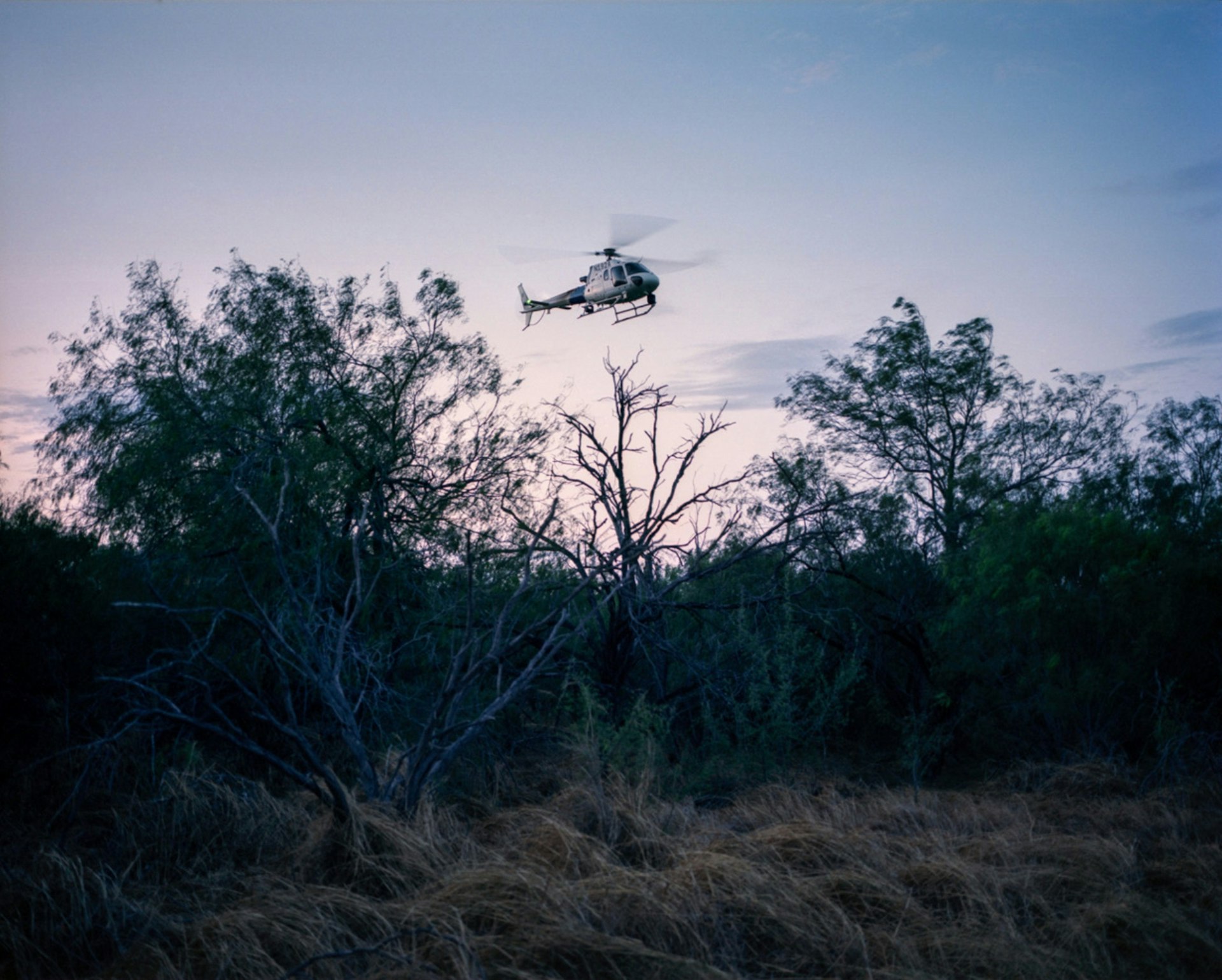 A US Border Patrol helicopter searches the brush for two men who were spotted by agents. They were never found.