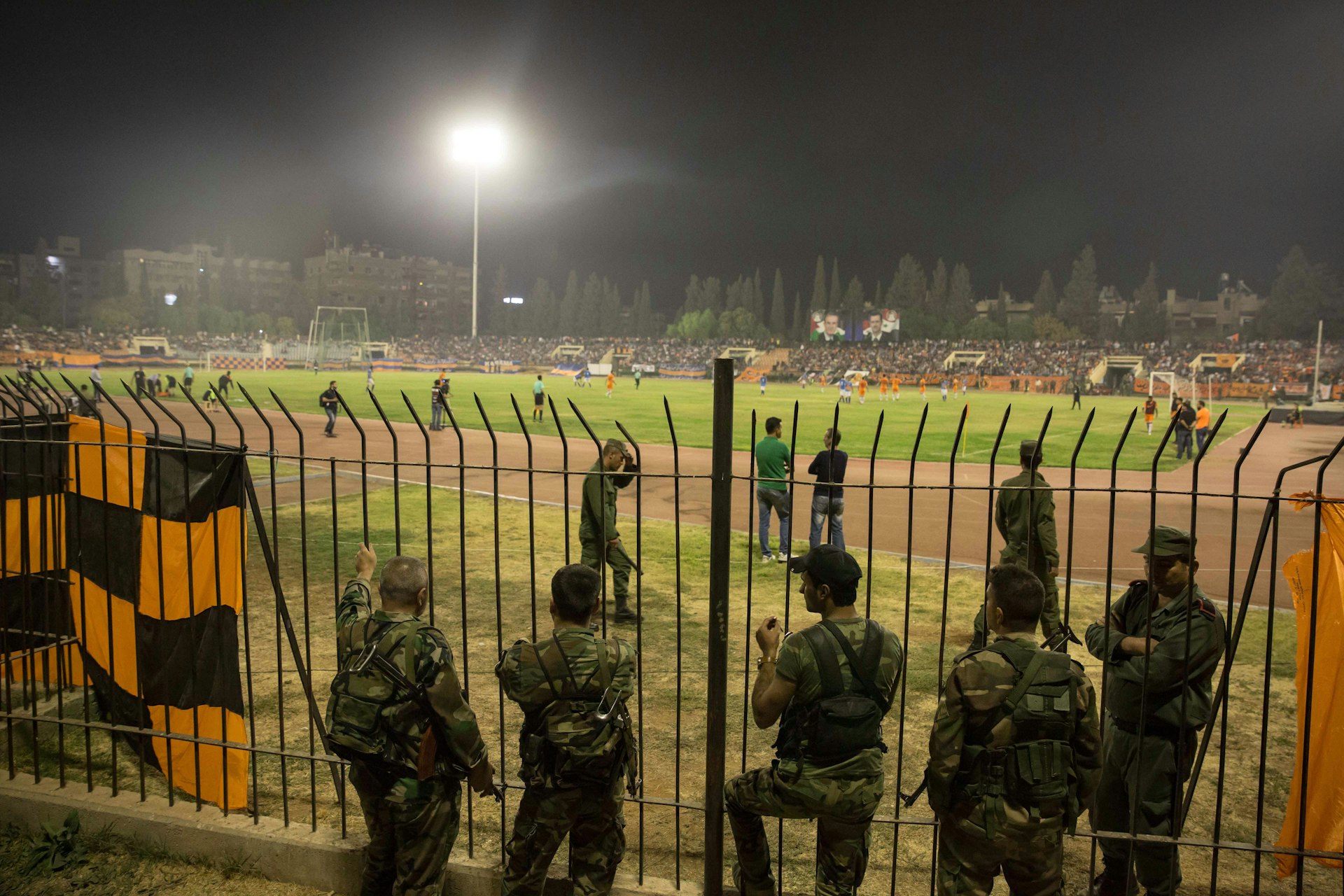 Soldiers line the pitch during the Syrian Cup final. Some also stood in the crowd, watching out for security breaches.