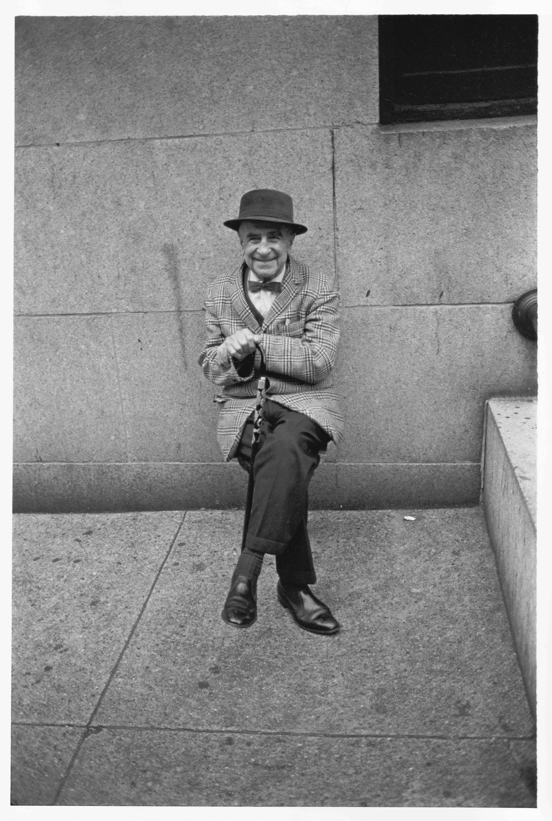 Gentleman resting at the side of a building, 1967
