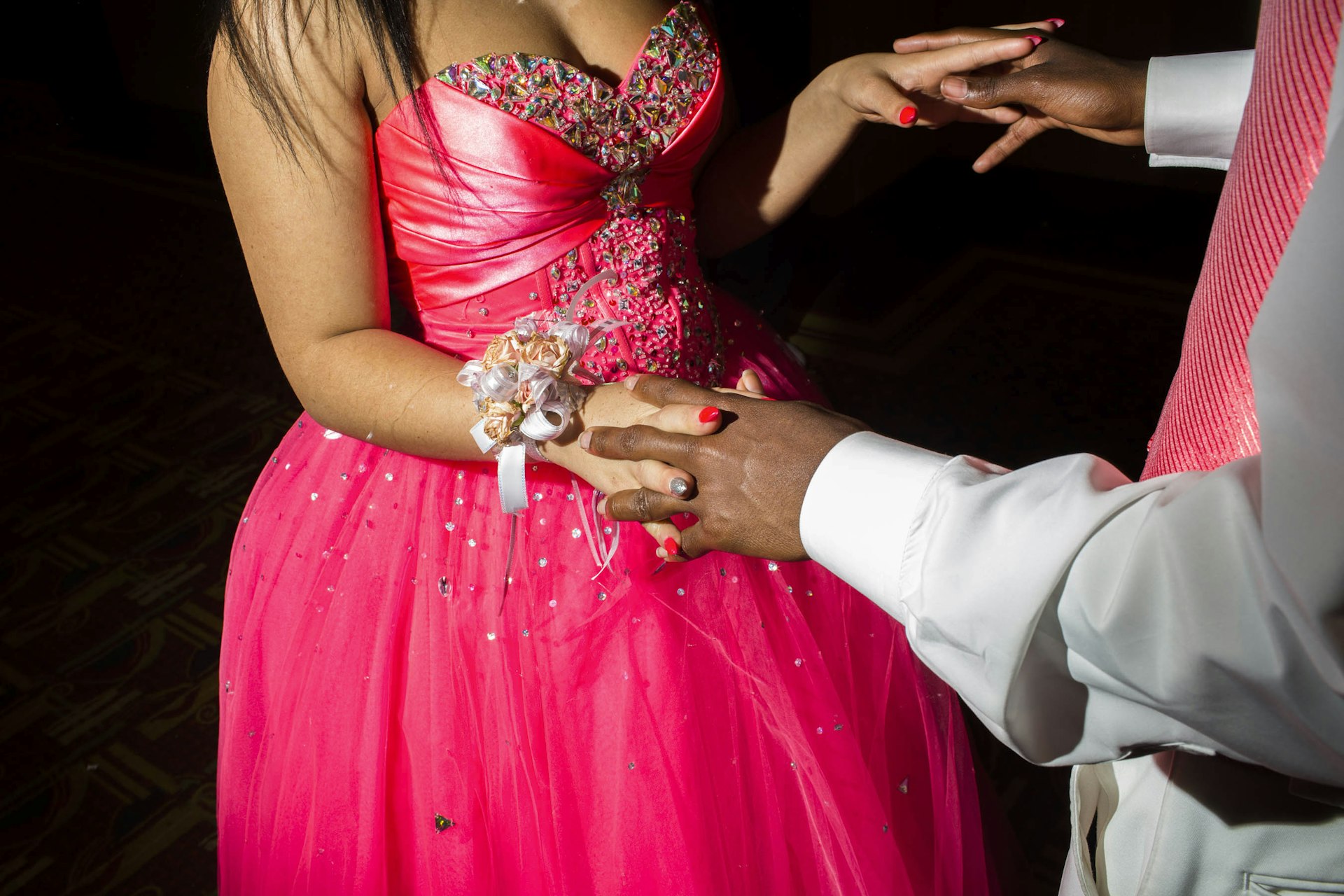 An unidentified couple holds hands while talking at their high school prom on Saturday, May 21, 2016 in Flint, Michigan.