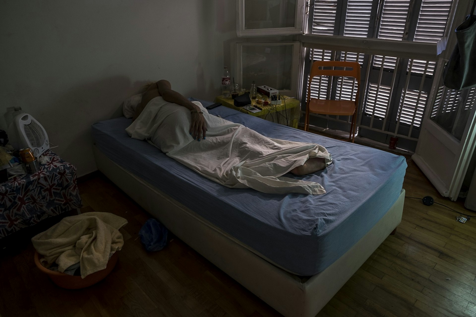 M., a transgender woman from Tunisia, takes a nap at her apartment in Athens, Greece. September 4, 2017