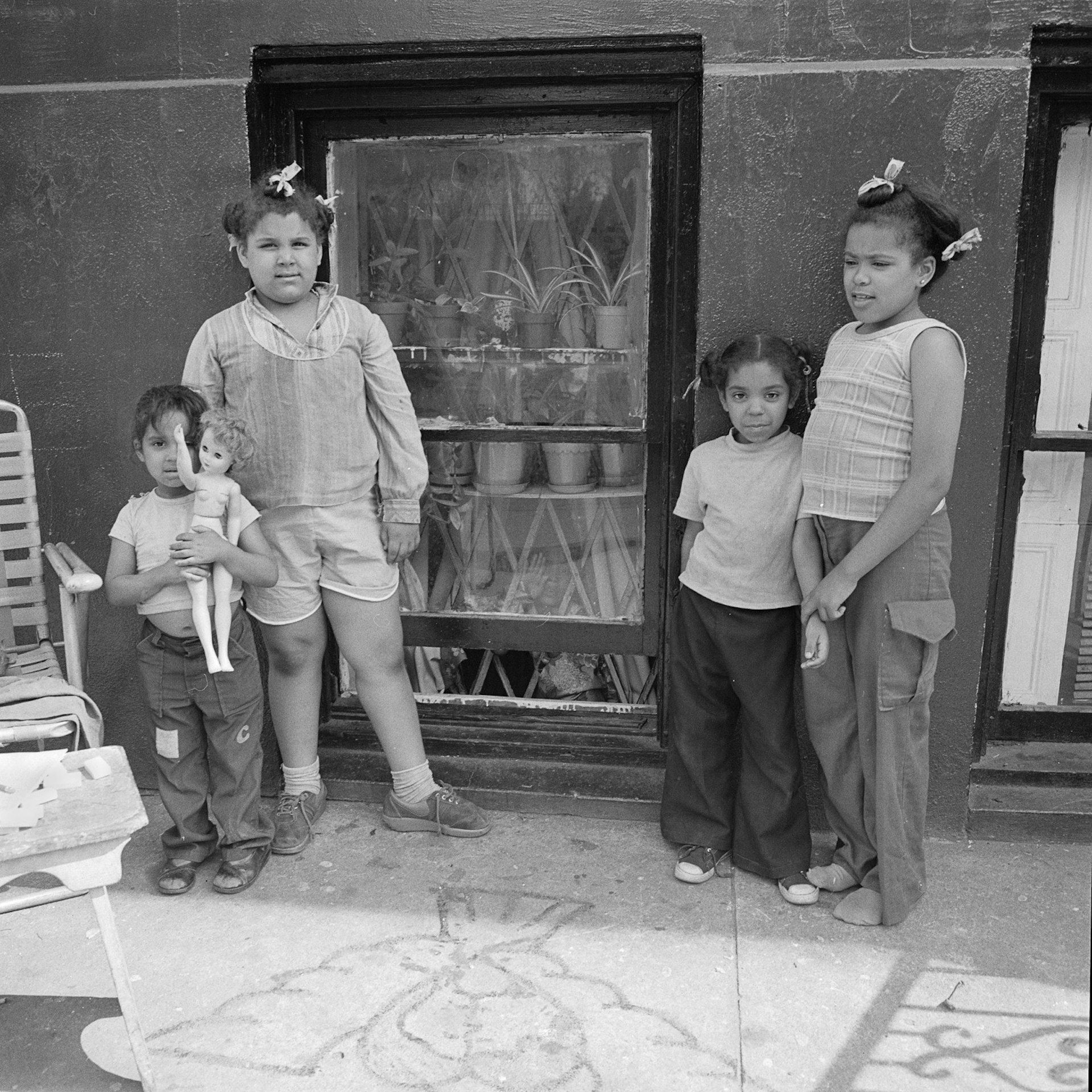Four kids and a doll in front of a window NY, NY June 1978