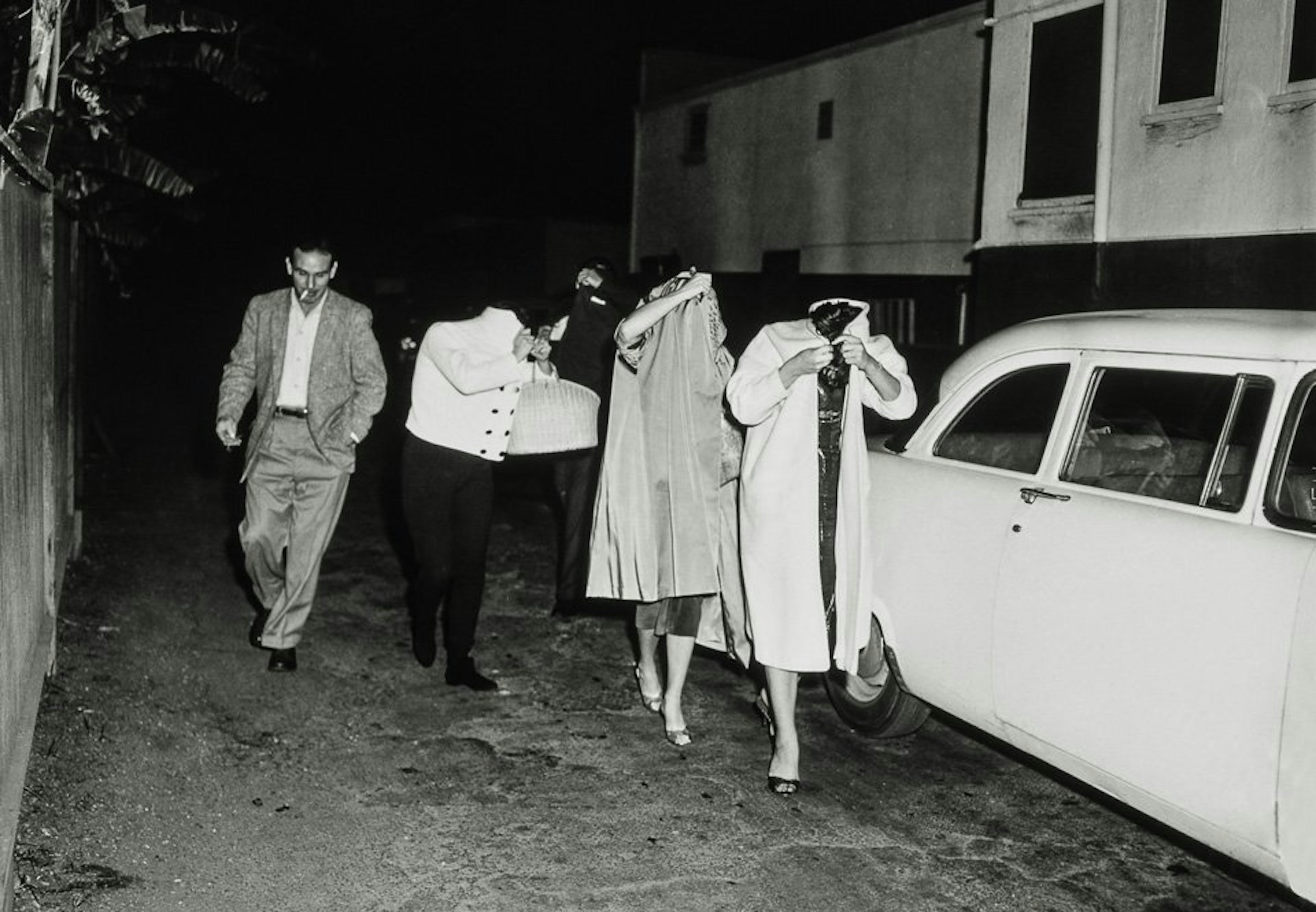 A bevy of hookers cover up after a vice squad raid at the Carolina Pines Restaurant on Melrose Avenue, ca. 1957. Copyright: Cliff Wesselmann, Photo Courtesy of Gregory Paul Williams, BL Press LLC / TASCHEN