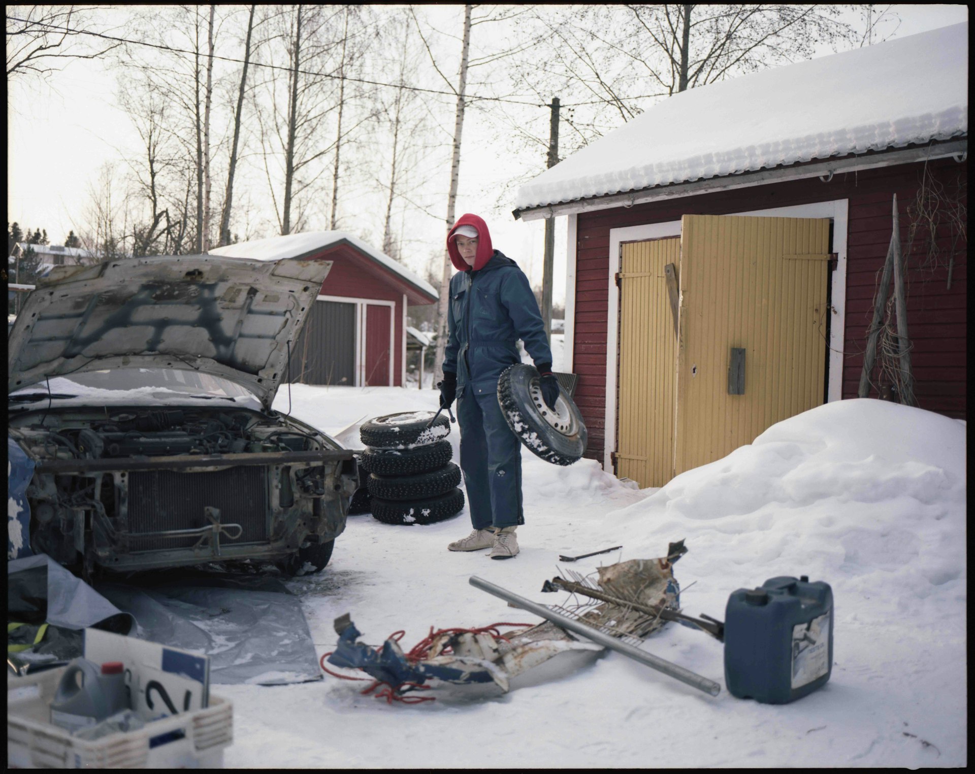 Eetu works on his car in the driveway at home.
