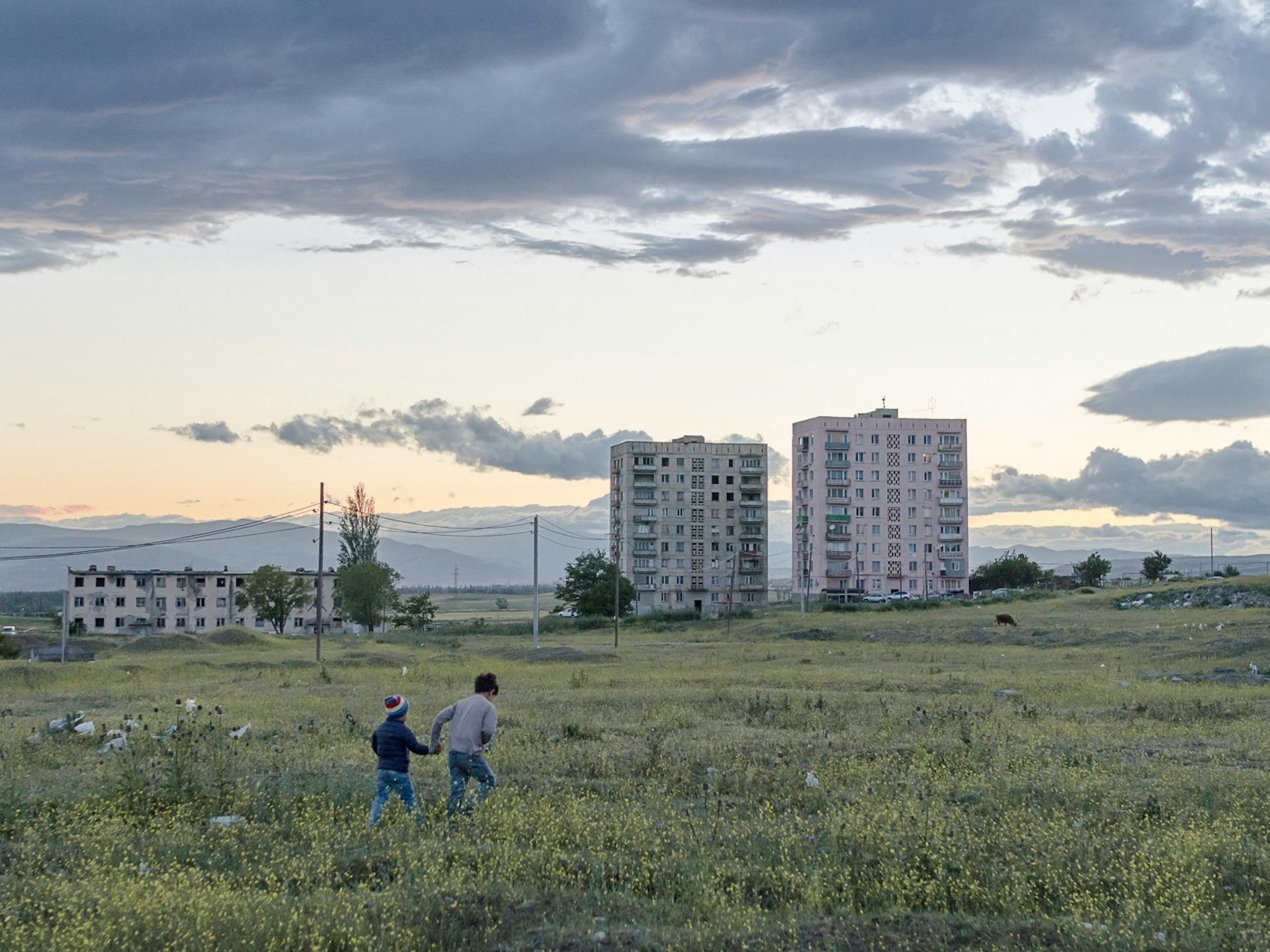 Two children roam around the broad fields at the periphery of the settlement. In demand for a suited playground, the inhabitants collected signatures for a petition to the government – they only received empty promises in return.