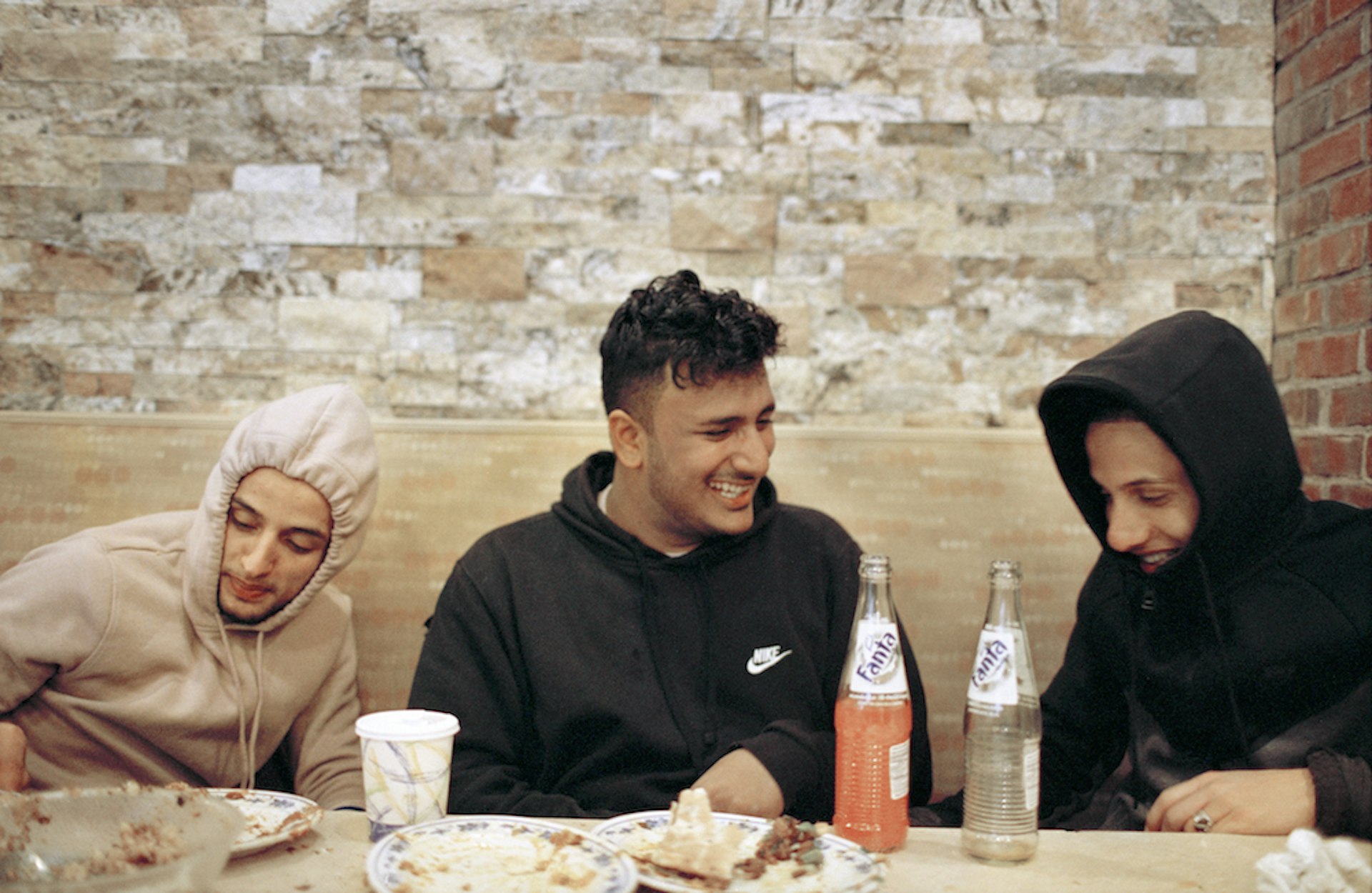 Othman Hussein, Sid Hatem and Ahmed Elsamet joke around during a late breakfast at a local Yemeni restaurant after an early morning soccer practice.