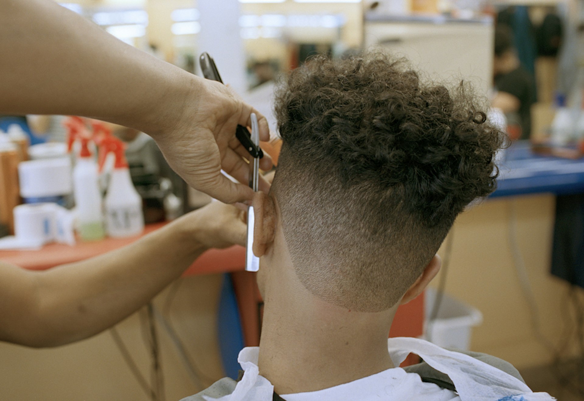 Ahmed Alzandhani  gets a medium skin fade the day before a soccer match at a Dominican barbershop in the Flatbush neighborhood of Brooklyn, New York.