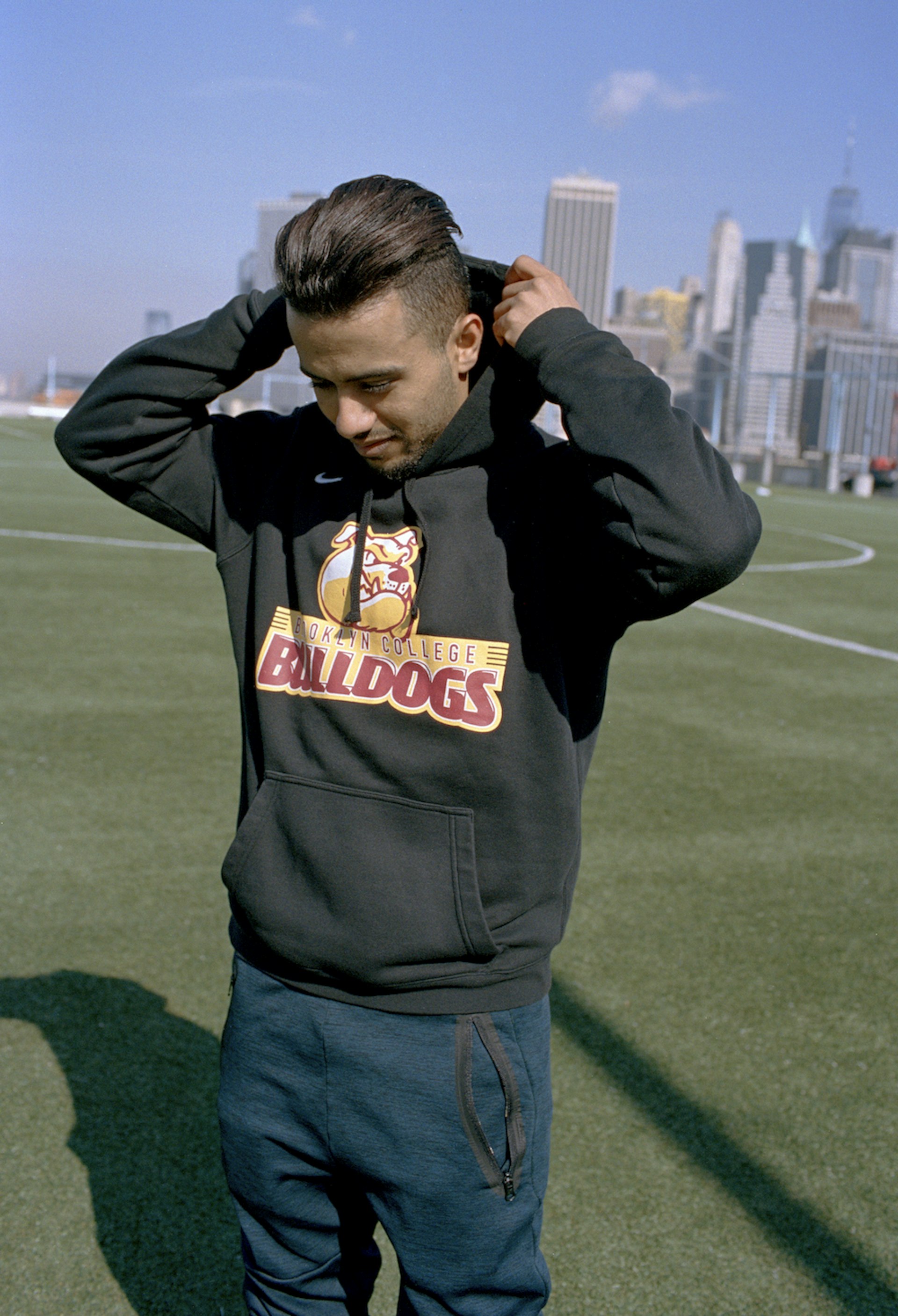 Mohamed Isa adjusts his hoodie on the field after a cold morning training session in Brooklyn, New York.