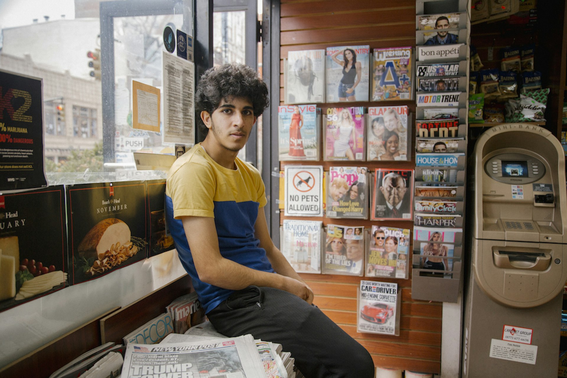 Osama Alsahybi, 20, sits in his brother's deli in the  Brooklyn Heights neighborhood of Brooklyn, New York. Osama has been in the U.S. for just under two years. Having zero English knowledge prior to coming to the US, he now speaks easily, laughs often and has made friends with all the regular customerrs who enter into the deli. To then, he's known simply as Oz.