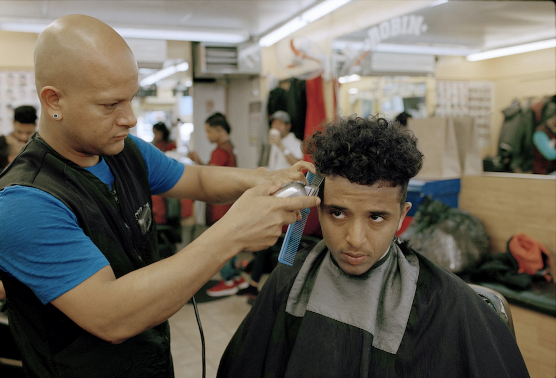 Ahmed Alzandhani gets a medium skin fade the day before a soccer match at a Dominican barbershop in the Flatbush neighbourhood of Brooklyn.