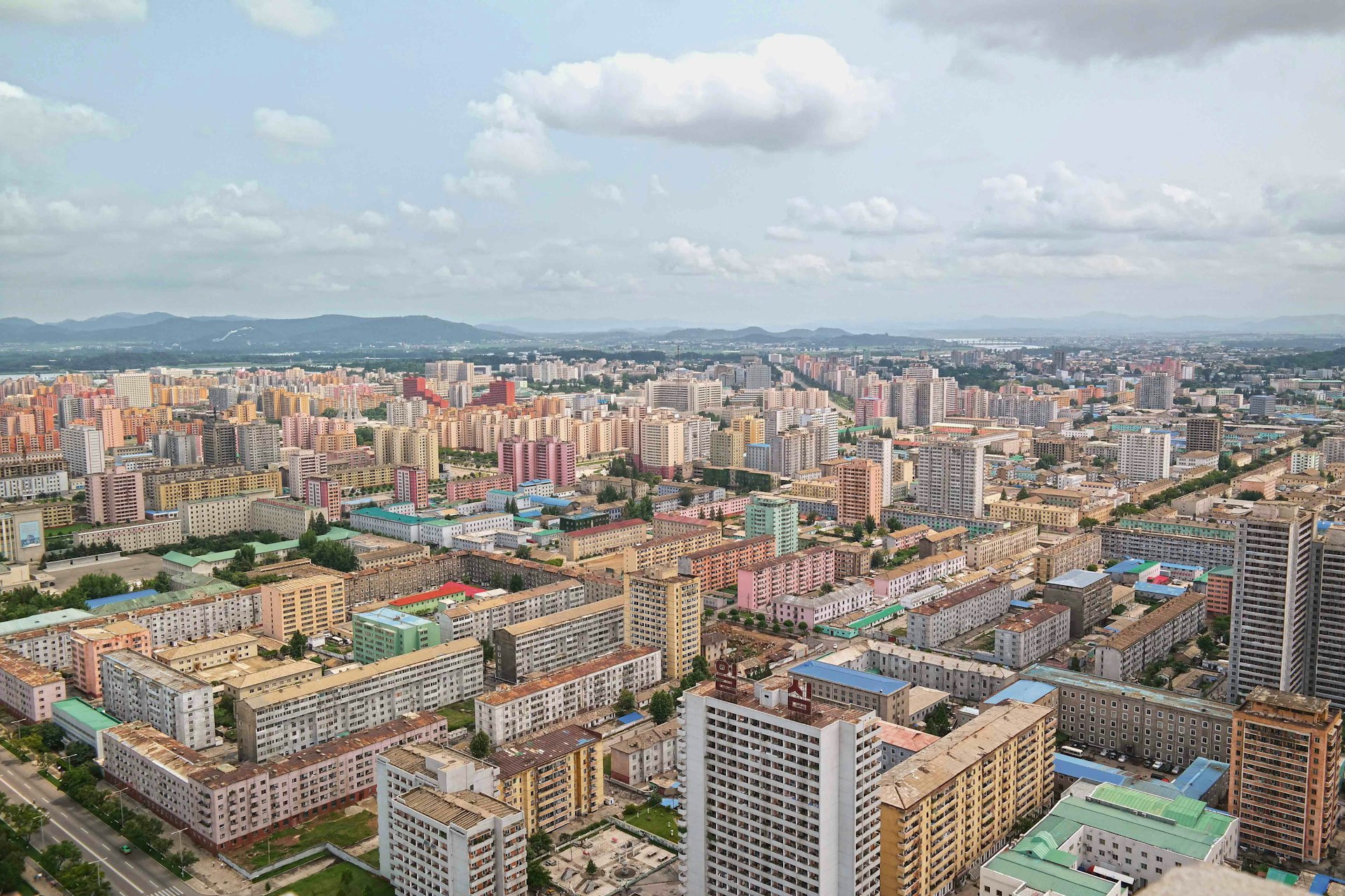 View from the top of the Tower of the Juche Idea in Pyongyang. The North Korean capital stretches out beneath you as a pastel-coloured panorama, a rolling field of tower blocks painted in terracotta and yellow ochre, turquoise and baby blue – a distinctive colour palette that recurs throughout the country’s architecture and interiors.