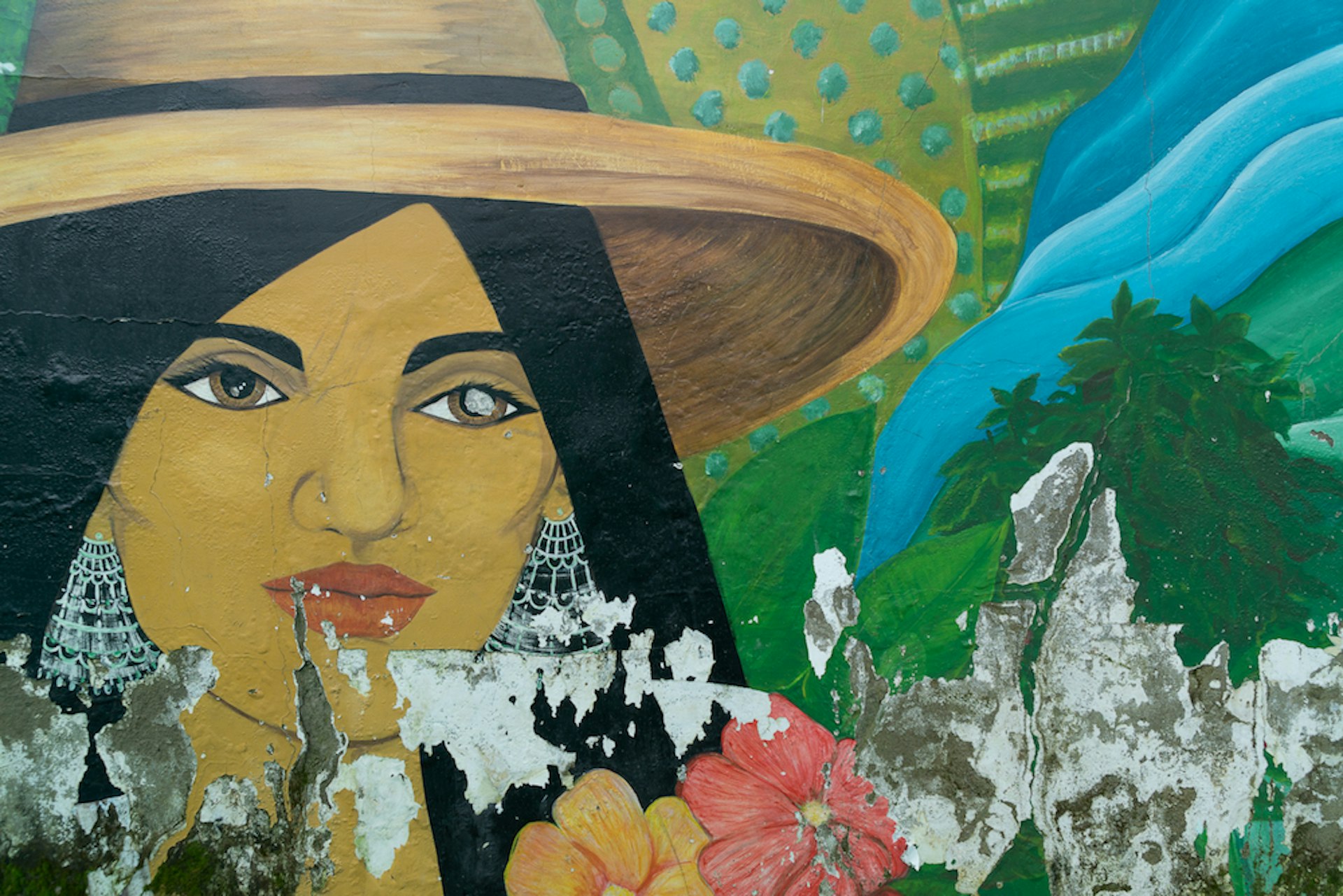 Detail shot of a mural near cafe La Floresta in Pijao depicting a woman in a wide brimmed sun hat