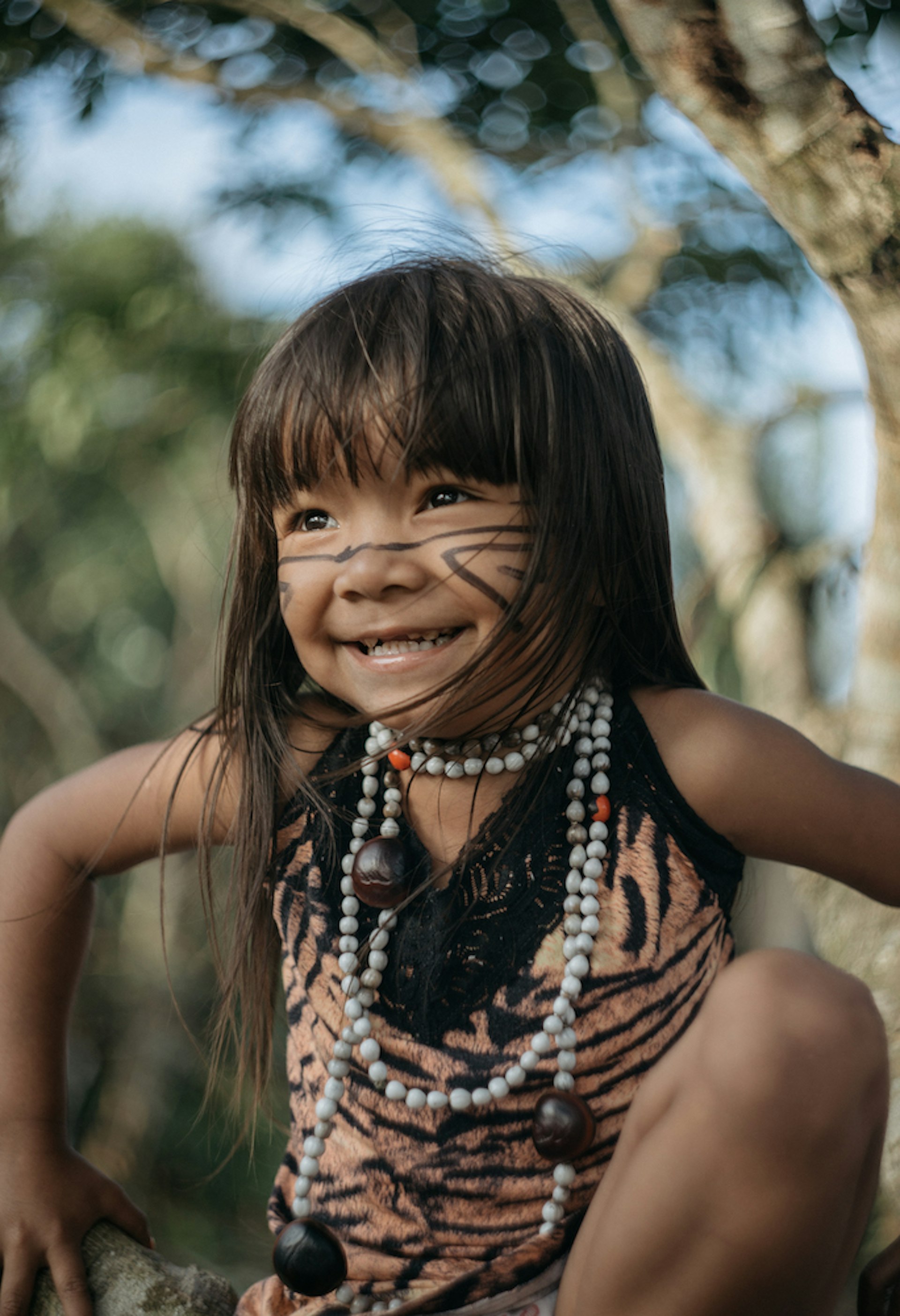 A young indigenous brazilian child wearing traditional clothing with facepaint 