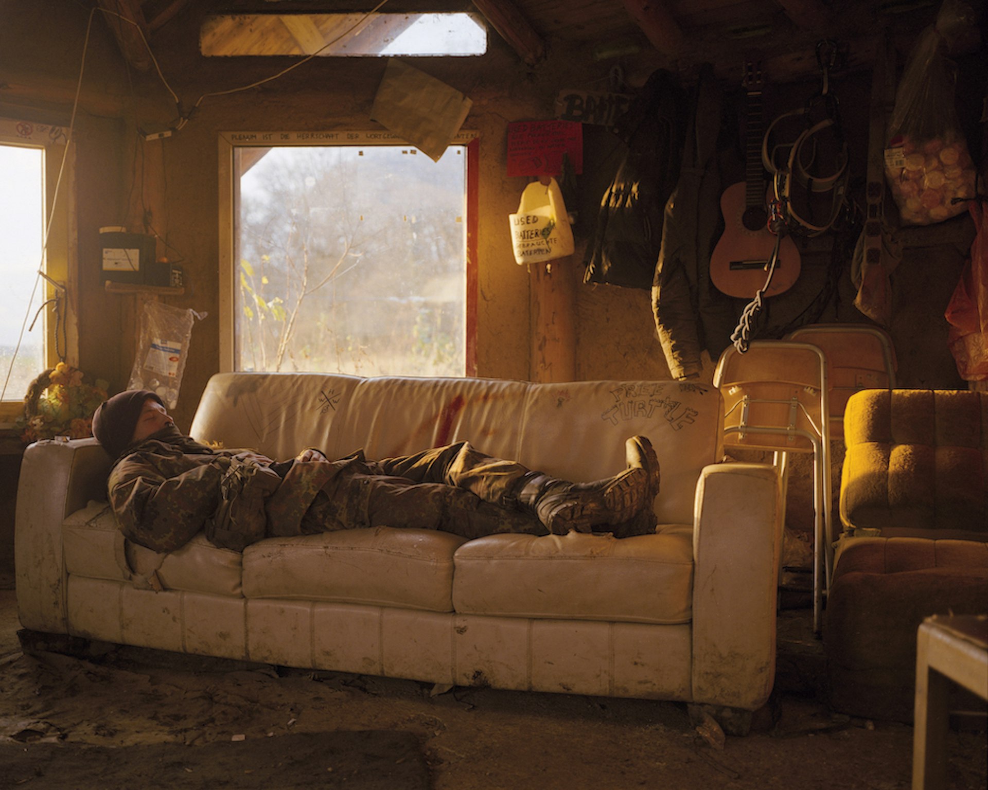 An ecoactivist in woodland camouflage reclines on a sofa 